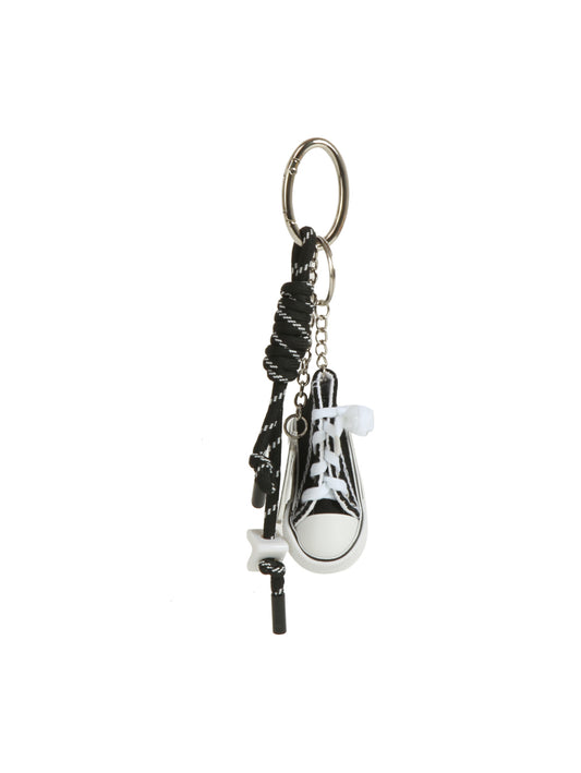 The HR Mini Sneaker Keychain features a black-and-white sneaker, coiled black cord, and sneaker charms on a silver keyring—an ideal streetwear-inspired accessory for your essentials.