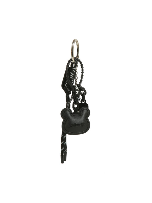 The HR Black Bear Charm Keychain features a modern black design with a bear charm, braided cord, and metal keyring, all in a sleek matching color scheme with decorative details.