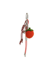 The HR Crochet Orange Keychain features a crocheted orange fruit with a green top, red and white cord, metallic accents, and a silver tassel keyring.