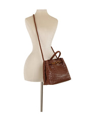 The LM Knot Accent Woven Tote, made of brown faux leather with a gold-tone knot detail and a shoulder strap, is shown on a cream dress form mannequin against a white background.
