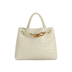 The LM Knot Accent Woven Tote is a cream-colored faux leather bag featuring two handles, a braided crossbody strap, and a gold-tone knot accent on the front.