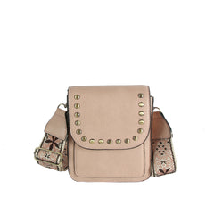 The LM Guitar Strap Flap Crossbody is a small beige bag with a studded flap closure and an adjustable embroidered floral guitar strap with a metal buckle.