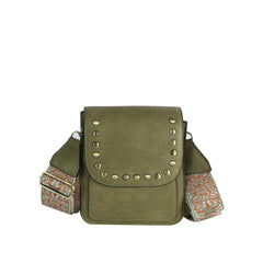 The LM Guitar Strap Flap Crossbody features an olive green, textured finish with a studded flap, gold studs, and a wide embroidered strap in orange and cream. A front pocket adds both style and function to this chic bag.